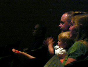 A young audience member applauds